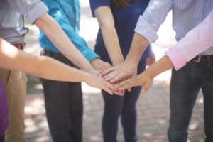 a group of people touching hands