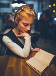 woman holding a book at risk for information overload