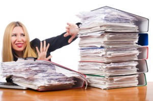 woman with pile of papers, writer's block