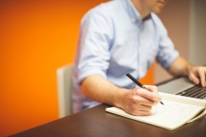 man using a pad and computer in his legal nurse consulting business
