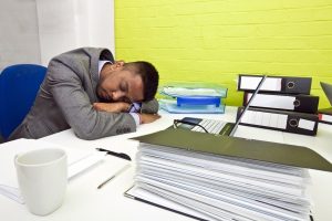 Man asleep by computer frustrated by need for natural sounding writing