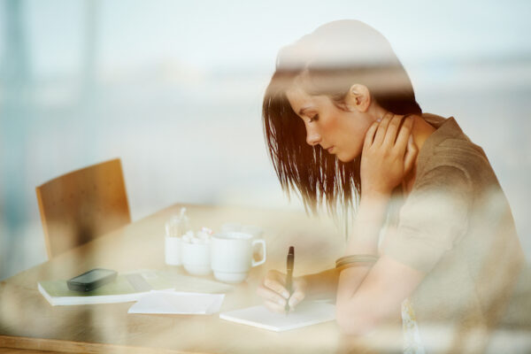 A young lady journaling with coffee