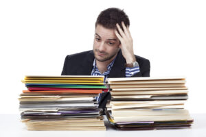 young_businessman_with_hand_in_head_looking_at_folders