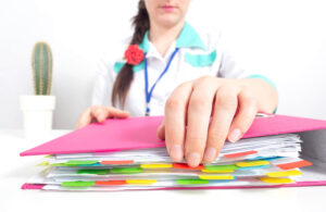 A medical worker opens a folder for documents