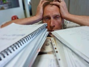 anxious man surrounded by medical records