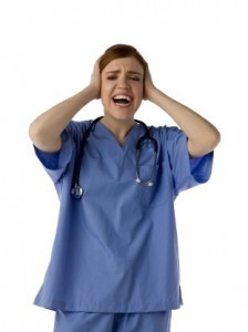 woman in surgical scrubs holding head